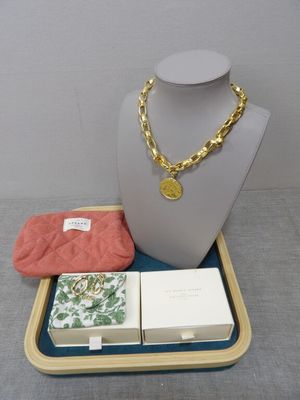 a necklace, wallet, and other items sitting on a tray