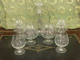 six verres à vin et une carafe posés sur une table