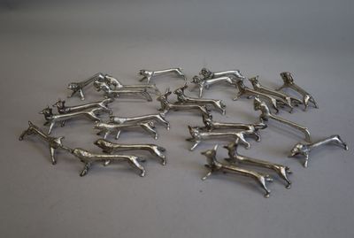 silver dog figurines are arranged in a circle on a white surface