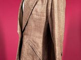 a brown suit on a mannequin stand against a red background