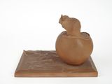a sculpture of a cat sitting on top of a vase