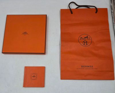 un sac en papier orange et un livre posés sur une table
