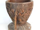 a wooden bowl with carvings on it on a white surface