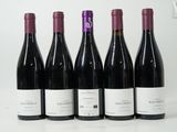 six bottles of wine are lined up on a table