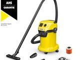 a yellow vacuum cleaner is sitting next to a spool of thread and a spool of thread