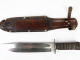 a knife and a knife sheath on a white surface