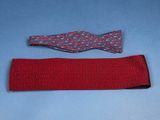 two pieces of red fabric with a bow tie on a blue surface