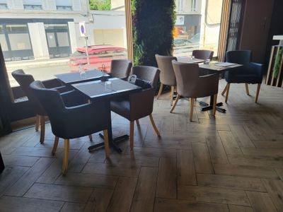 tables and chairs in a restaurant with a view of a street