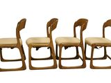 four wooden chairs with beige upholstered upholstered seats