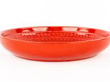 red bowl on a white surface with a white background