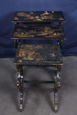 three black painted nesting tables sitting on top of a gray floor
