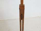 a wooden sculpture of a man holding a knife on a stand