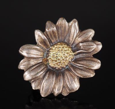 un gros plan d'une fleur en métal sur une surface noire