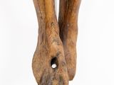 a wooden sculpture of a person ' s feet with a hole in the middle
