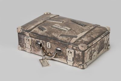 an old suitcase with a lock on it on a white surface