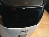 a black and white air fryer sitting on a wooden table