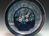 a blue plate with a basket of flowers on it