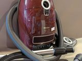 un aspirateur rouge posé sur un plan de travail