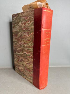 an old book sitting on top of a table next to a wall