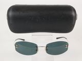 Lunettes de soleil Chanel et leur étui posés sur une surface blanche, avec un étui en cuir noir