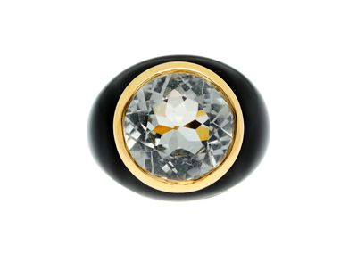 a close up of a black and gold ring with a white diamond