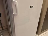 un petit réfrigérateur blanc dans le coin d'une cuisine