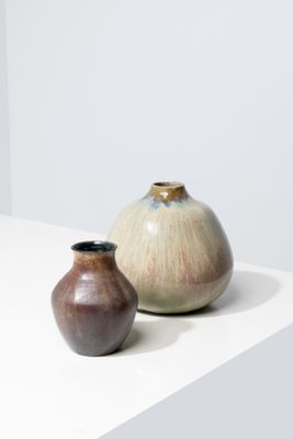 deux vases posés sur une table blanche, sur fond blanc