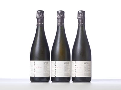 trois bouteilles de vin posées sur une table l'une à côté de l'autre