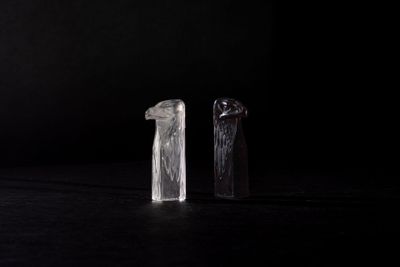 two pieces of glass on a table with a black background