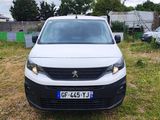 une camionnette blanche garée sur un parking avec d'autres voitures