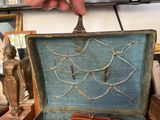 a hand that is holding a piece of art in a box