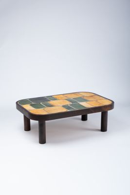 une photo d'une table basse avec un plateau carrelé et des pieds en bois