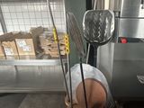 several kitchen utensils are on a stand in a warehouse