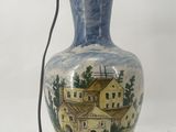 a blue and white vase that has a painting on it