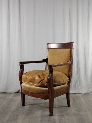 une image représentant une chaise avec un coussin posé dessus, devant un rideau blanc