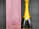 un gros plan sur une bouteille de champagne à côté d'une boîte rose