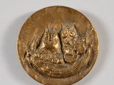 une image représentant une médaille d'or sur laquelle figurent un homme et une femme dans un bateau