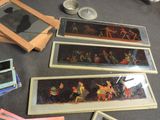 four framed pictures of people on a table next to a mirror