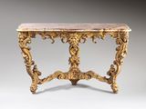 an ornately carved console table with marble top