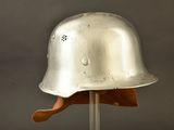 silver helmet on a wooden stand against a gray background