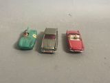three toy cars sitting next to each other on a table