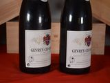 two bottles of wine sitting next to each other on a table
