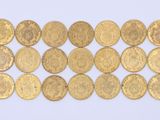 several gold coins are arranged in a row on a white surface