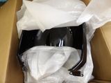 a box with a black object in it that is wrapped in tissue