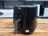 une friteuse à air chaud noire posée sur une table dans un magasin
