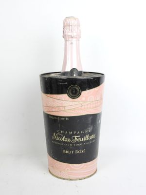 une image représentant une bouteille de champagne dans un seau à glace noir et rose