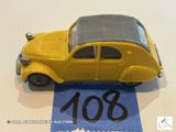 a yellow toy car sitting on top of a blue ribbon