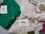 three sweaters and a hat are laid out on a table