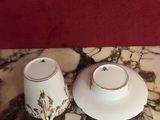 two cups and saucers sitting on a marble table