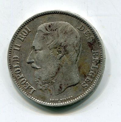une vieille pièce de monnaie avec un visage d'homme sur une surface blanche